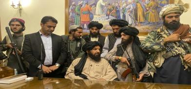 Taliban fighters take control of Afghan presidential palace after the Afghan President Ashraf Ghani Fled the Country, in Kabul, Afghanistan, Sunday, Aug,15,2021. Person second from left is a former bodyguard for Ghani. (AP Photo/Zabi Karim)