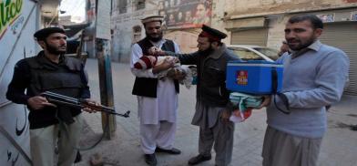 Policeman guarding polio worker