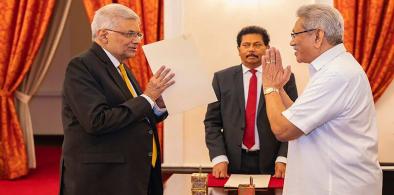 President Gotabaya Rajapaksa (right) greets Ranil Wickremesinghe during the latter's oath taking ceremony as the new prime minister, in Colombo on Thursday