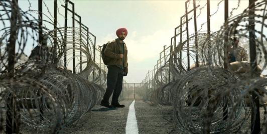 Screen shot of actor Diljit Dosanjh who portrays Nirvair Singh in the film Main Vaapas Aaunga, standing between two countries. Screenshot via film.