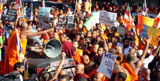 Sri Lankan Buddhist monks shout slogans and hold placards as they stage a protest rally outside the Bangladesh High Commission in Colombo